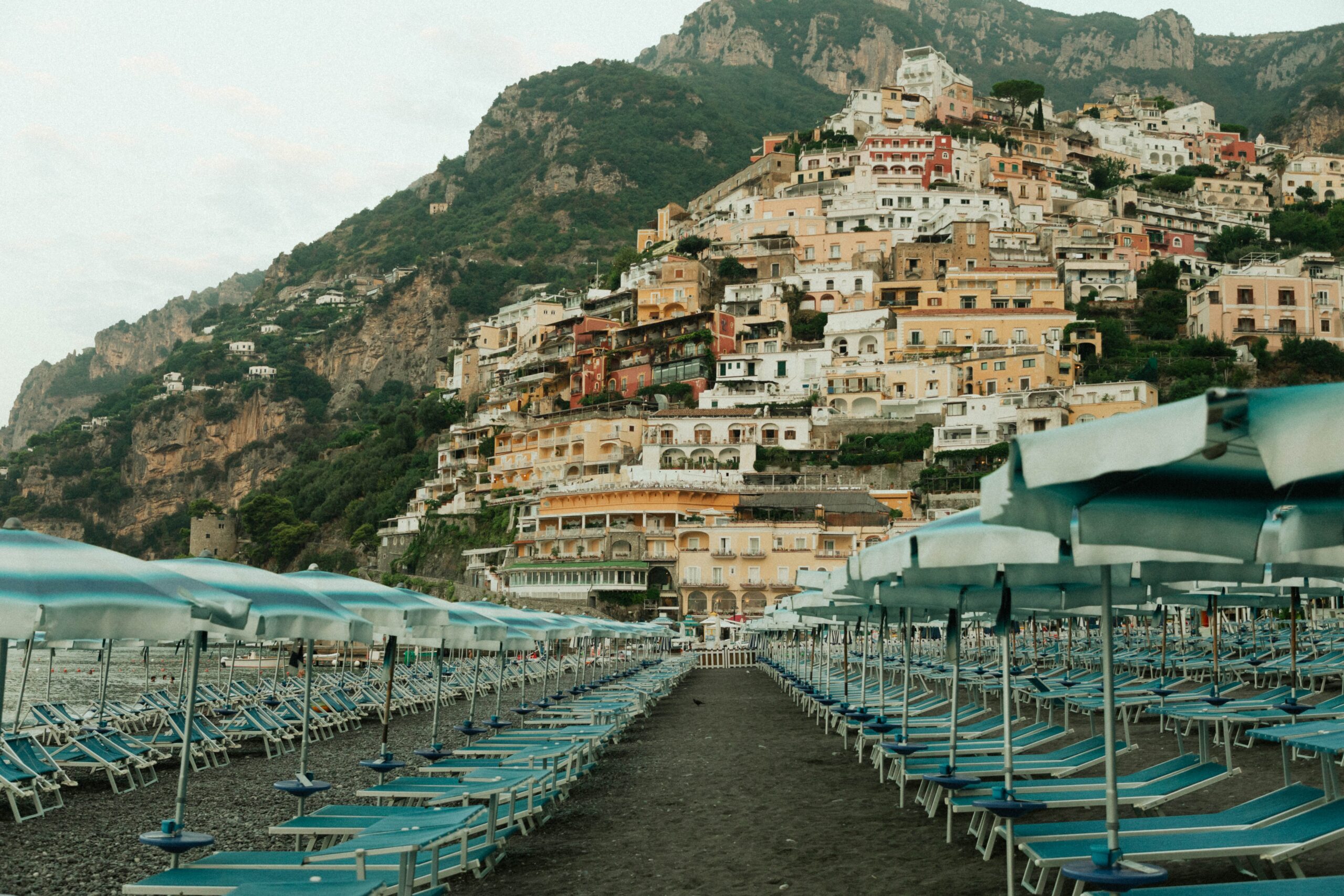 The colorful cliffside village of Positano and its beach umbrellas on the Amalfi Coast, an Italy destination wedding location