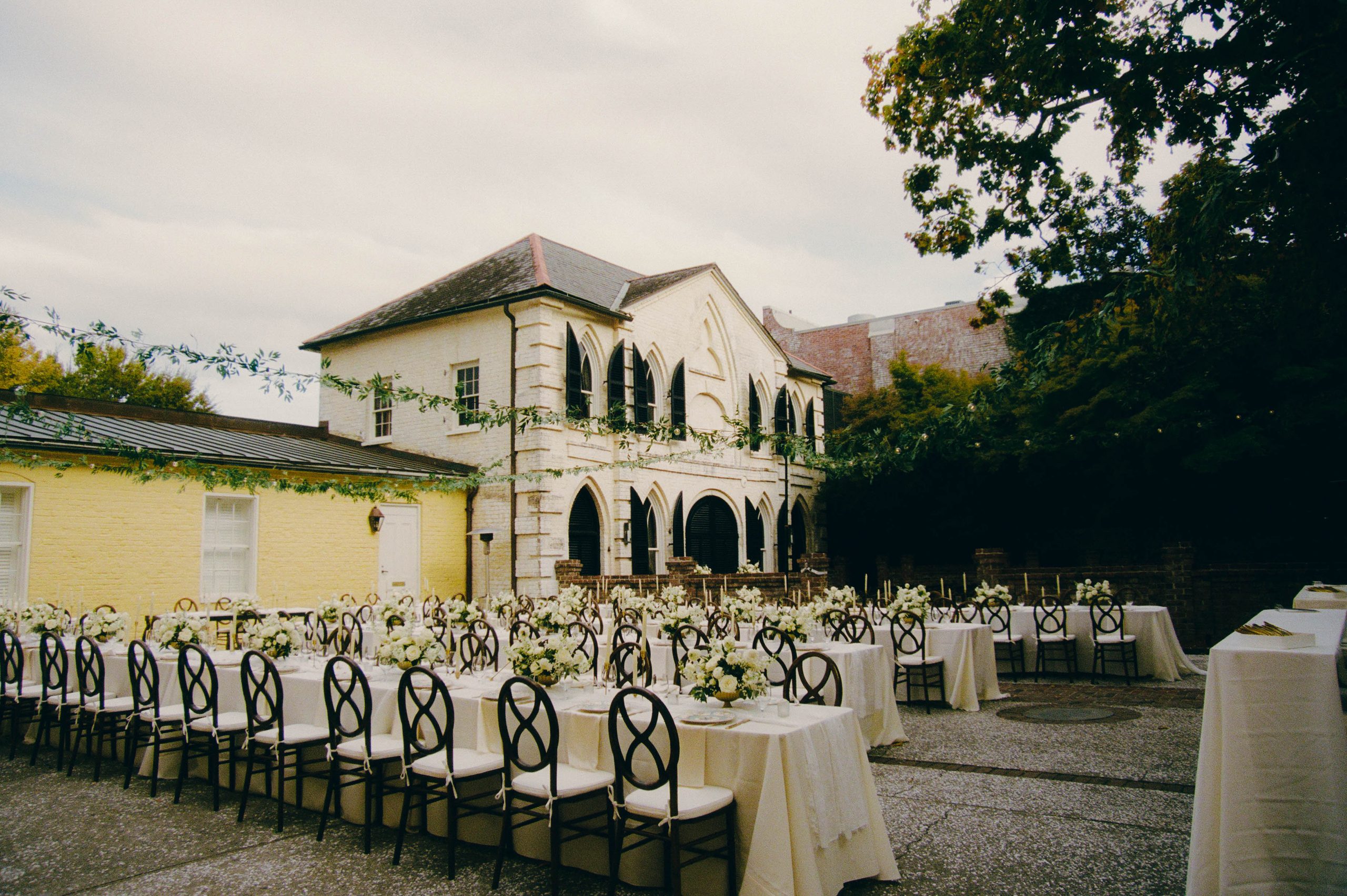 Courtyard reception tables set beneath the historic William Aiken House in downtown Charleston