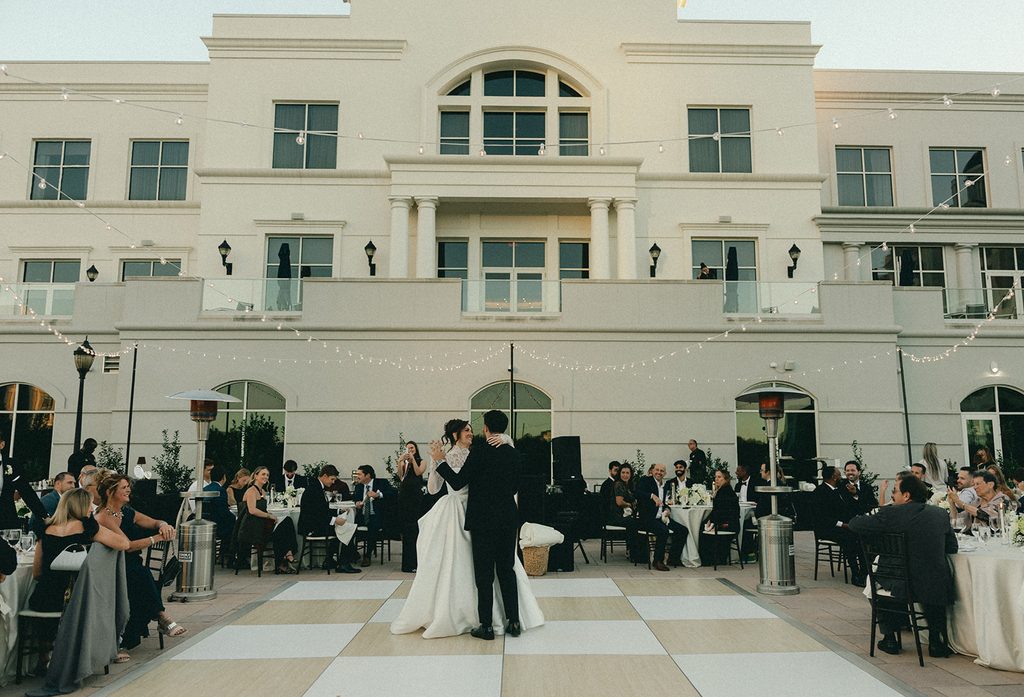 Bride and groom sharing their first dance on the terrace under string lights at their Ballantyne Hotel wedding reception in Charlotte, NC