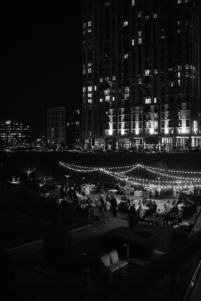 Black and white night view of a wedding reception under string lights at The Ballantyne in Charlotte, NC